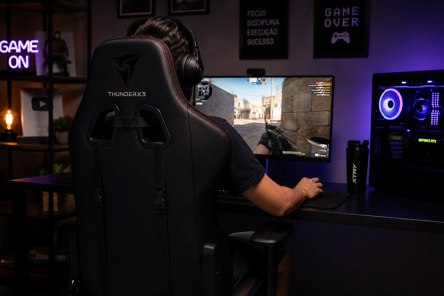 Pessoa jogando em um computador gamer com iluminação neon roxa e monitor